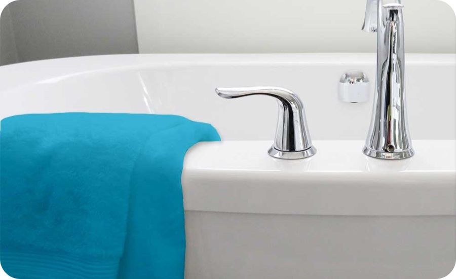 Serviette de bain bleu canard en coton posée sur le bord d'un